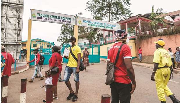 Some people wear masks as they walk by the entrance to the Yaounde General Hospital in Cameroon, yesterday.