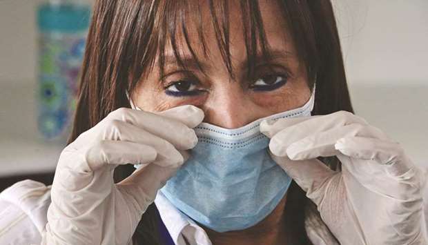 A woman wears a protective face mask as a precaution against the spread of the new coronavirus, Covid-19.