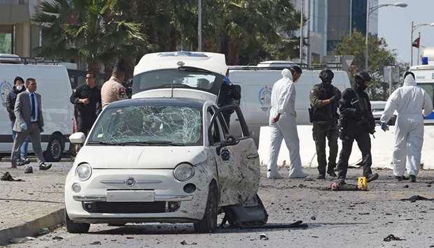 Police and forensic experts inspect the scene of an explosion near the US embassy in the Tunisian capital Tunis, yesterday.