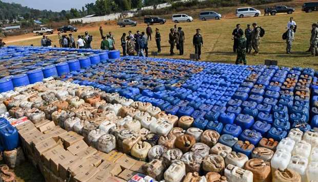 Foreign military attachu00e9s check drugs in a football ground where seized drugs, vehicles, laboratory accessories and precursor chemicals are being displayed to be witnessed by invited military attachu00e9s and journalists in Kawnghka at Shan State