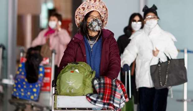 People wear face masks upon their arrival at Beijing Capital Airport, as the country is hit by an outbreak of the novel coronavirus, in Beijing, China, on March 4