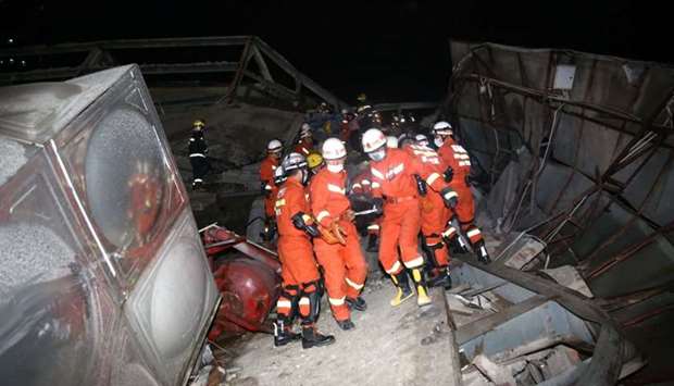 Rescue workers move casualty on the site where a hotel being used for the coronavirus quarantine collapsed, as the country is hit by the novel coronavirus, in the southeast Chinese port city of Quanzhou, Fujian province, China
