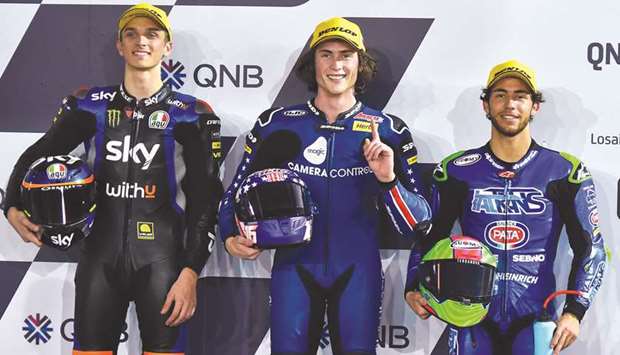 Pole position winner American Moto2 rider Joe Roberts  (centre) of American Racing poses with second placed Italian Moto2 rider Luca Marini (left) of SKY Racing Team VR46 and third placed Italian Moto3 rider Enea Bastianini of Italtrans Racing Team after the qualifying session of the Motorcycling Grand Prix of Qatar at the Losail International Circuit in Doha yesterday.
