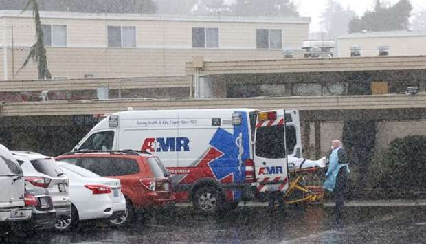 A patient is put into an ambulance during the pouring rain outside the Life Care Center of Kirkland on March 7, 2020 in Kirkland, Washington