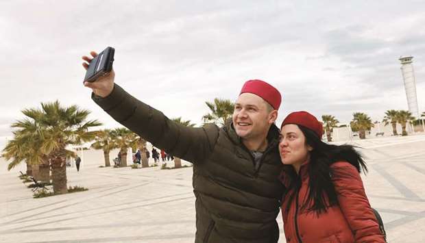 Tourists take a selfie after arriving to Tunisia at the Enfidha Airport in Enfidha (file). Tunisia will seek a new loan deal with the International Monetary Fund (IMF), its prime minister said yesterday, after slashing the countryu2019s economic growth forecast for this year due in part to the impact of the coronavirus crisis on tourism.