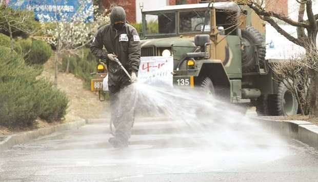 A South Korean soldier sprays disinfectants at an apartment complex which is under cohort isolation after mass infection of coronavirus disease reported in Daegu, South Korea, yesterday.