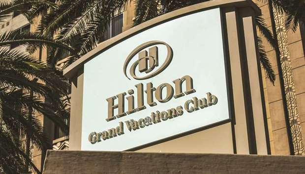 Signage for a Hilton Worldwide Holdings Grand Vacations Club hotel stands in Las Vegas. Hilton Grand Vacations shareholders will own about 72% of the combined company with Apollo and other Diamond shareholders owning approximately 28%, according to a statement.