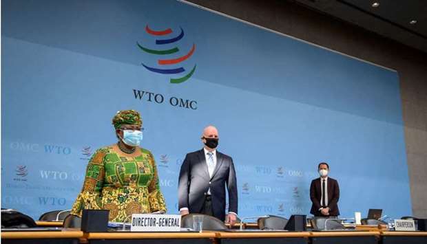 New Director-General of the World Trade Organisation Ngozi Okonjo-Iweala (L) stands prior to a session of the WTO General Council upon her arrival at the WTO headquarters to takes office in Geneva on March 1, 2021