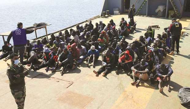 Rescued migrants sit aboard a Libyan coastguard vessel arriving at the capital Tripoliu2019s naval base, yesterday.