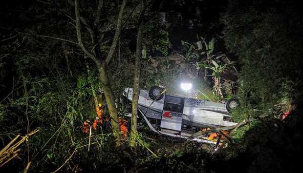 Rescue personnel work at the crash site after a bus fell into a ravine in Sumedang, West Java Province, Indonesia