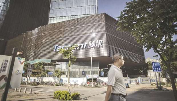 A pedestrian walks past Tencent Holdings headquarters in Shenzhen. Asiau2019s largest conglomerate was censured by Chinau2019s antitrust watchdog yesterday as Beijing expands a crackdown that began with Jack Mau2019s online empire.