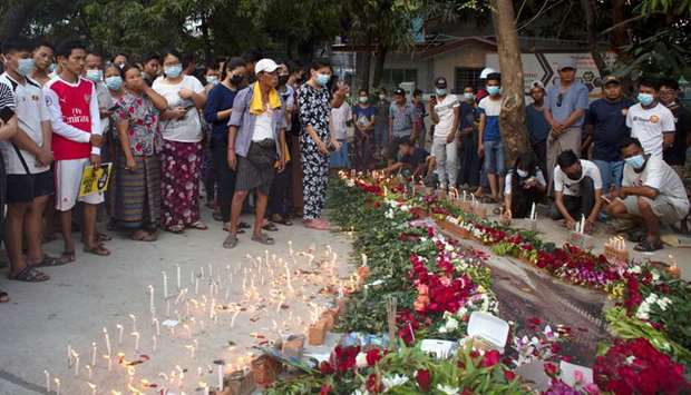 People lay down flowers and candles at the spot where the protester Chit Min Thun died during an ant