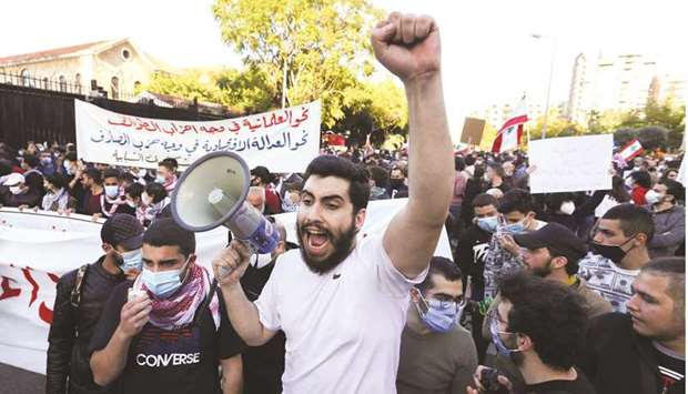 A demonstrator gestures while carrying a megaphone during a protest in Beirut.