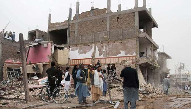 Residents inspect the site after a car bomb blast in Herat province, Afghanistan