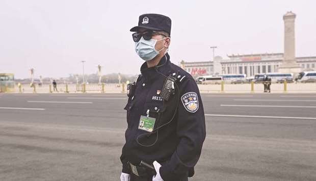 A police officer keeps watch outside the Great Hall of the People ahead of the closing session of the National Peopleu2019s Congress (NPC) in Beijing on March 11. Having powered its way out of the coronavirus lockdown to become the only major economy in the world to grow last year, China is also seen taking the lead on earnings recovery from the pandemic.