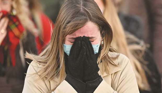 A well-wisher reacts as people gather at a band-stand where a planned vigil in honour of murder victim Sarah Everard was cancelled after police outlawed it due to Covid-19 restrictions, on Clapham Common, south London yesterday. (AFP)