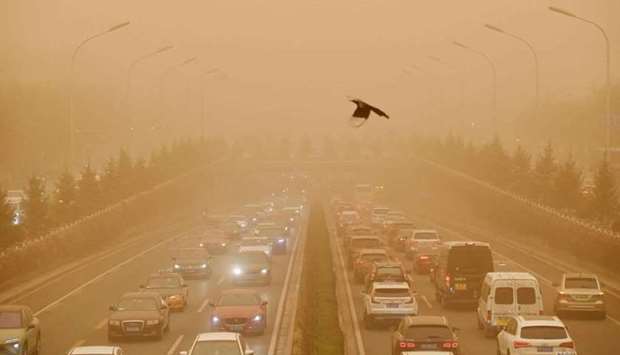 Motorists commute on a road during a sandstorm in Beijing