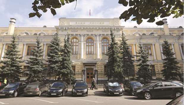 Pedestrians pass the entrance to the headquarters of Russiau2019s central bank in Moscow. The Bank of Russia is considering moving faster than previously signalled to tighten monetary policy and may bring its key interest rate up by 125 basis points or more before the end of the year.