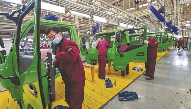 Employees work on a truck assembly line at a factory for the vehicle manufacturing company Jianghuai Automobile Group Corp in Qingzhou in eastern Chinau2019s Shandong province yesterday. Chinau2019s factory and retail sector activity surged in the first two months of the year, beating expectations, as the economy consolidated its brisk recovery from the coronavirus paralysis of early 2020.