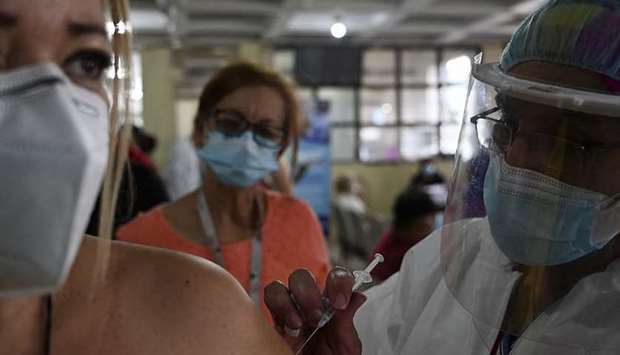 A nurse inoculates a woman with an AstraZeneca vaccine against Covid-19 at the Alonso Suazo healthcare center in Tegucigalpa