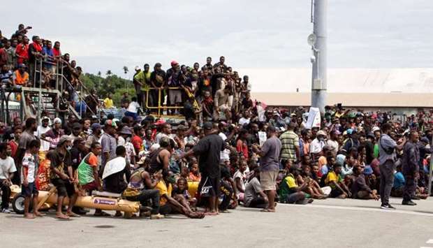 A crowd of people - none wearing face masks, nor keeping social distancing - gathered on March 14 outside Jacksons International Airport, Port Moresby to bid farewell to the casket of Papua New Guinea's first prime minister Michael Somare, who died late February