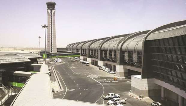 Airport service vehicles stand outside the passenger terminal at Muscat International Airport.