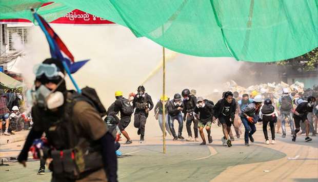 Protesters run during a crackdown of an anti-coup protests at Hlaing Township in Yangon, Myanmar