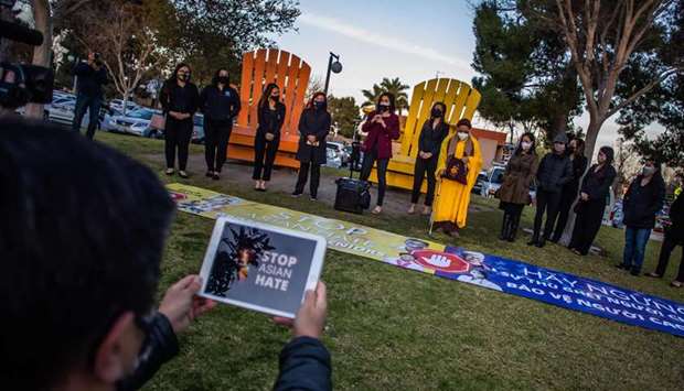 People gather for a candlelight vigil in Garden Grove, California, to unite against the recent spate of violence targeting Asians and to express grief and outrage after yesterday's shooting that left eight people dead in Atlanta, Georgia