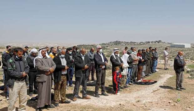 Palestinian demonstrators attend Friday prayers during a protest against Israeli settlements, in Yatta in the Israeli-occupied West Bank. REUTERS