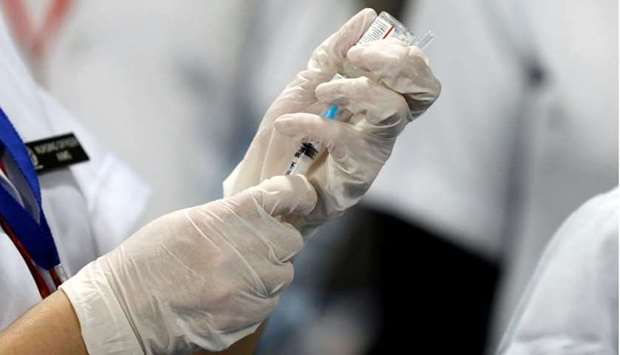 A healthcare worker fills a syringe with a dose of Bharat Biotech's Covid-19 vaccine called Covaxin, during the coronavirus disease vaccination campaign at All India Institute of Medical Sciences hospital in New Delhi, India on January 16