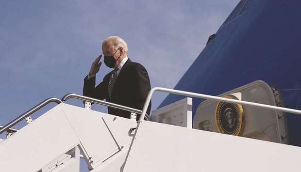 Biden salutes after earlier stumbling as he ran up the stairs to Air Force One.