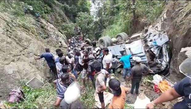 Rescue workers and locals surround the wreckage of the bus which plunged down a precipice in Passara. Photo courtesy of Daily Mirror, Sri Lanka