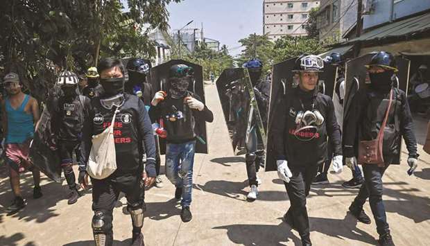 Protesters wearing protective gear carry shields during a demonstration against the military coup in Yangon.