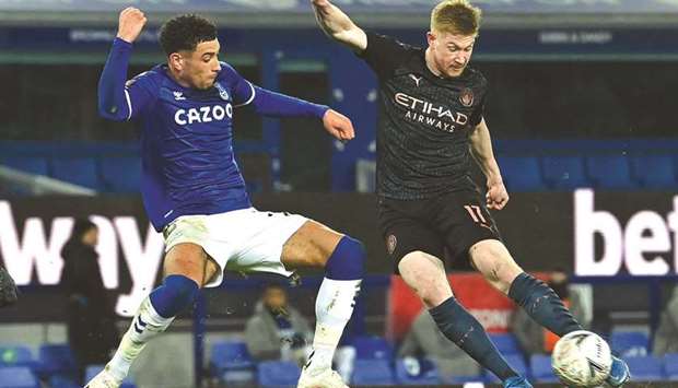 Manchester Cityu2019s Kevin De Bruyne (right) scores past Evertonu2019s Ben Godfrey during the FA Cup quarter-final at Goodison Park in Liverpool, north west England, yesterday. (AFP)