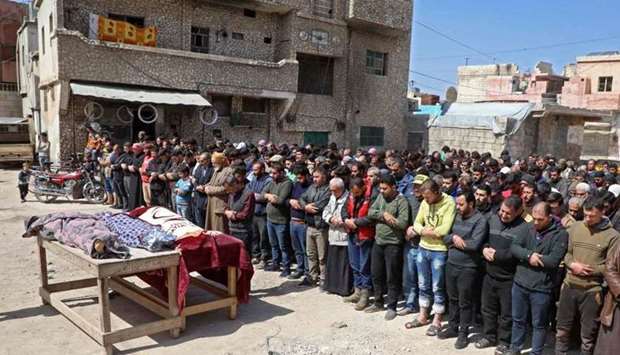 Syrian mourners pray during a funeral in the the village of Atareb in the northern Syrian province of Aleppo for civilians killed in regime artillery fire on a hospital.