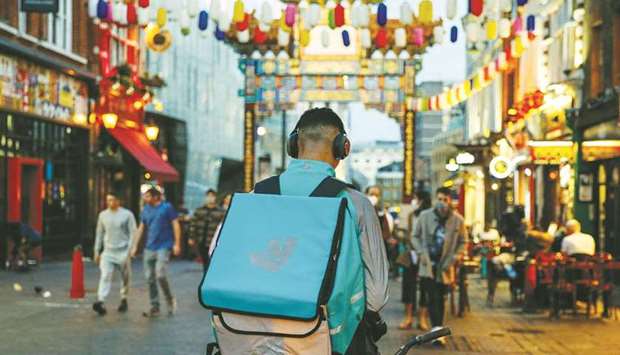 A takeaway food courier, working for Deliveroo, operated by Roofoods, stops in the Chinatown district of London.  Deliveroo started taking investor orders in a share sale of as much as $2.45bn, marking the largest initial public offering in the UK since September.