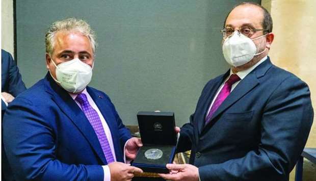 Qatar's ambassador to France Sheikh Ali bin Jassim al-Thani receives a copy of a bronze medal issued by La Monnaie de Paris from President and CEO of La Monnaie de Paris Marc Schwartz