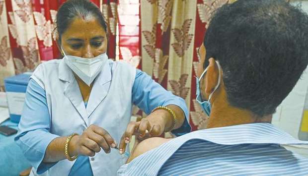 A medical worker inoculates a man with the Covid-19 vaccine at a vaccination centre in New Delhi, yesterday.