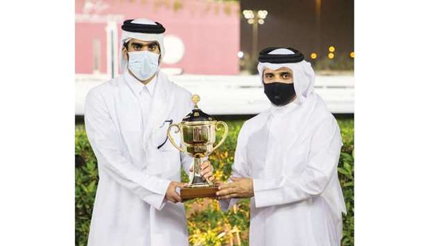 QREC Acting CEO Bader bin Mohamed al-Dariwsh (right) presents the owner's trophy to Jassim bin Hamad al-Attiyah after Al Sakab Stud's Al Faisaliya won the Al Britha Cup at Al Rayyan Park on Thursday. PICTURES: Juhaim