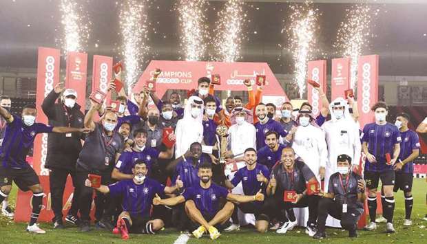 Al Sailiya players and support staff celebrate with the Ooredoo Cup trophy after defeating Al Rayyan in the final at the Jassim bin Hamad Stadium