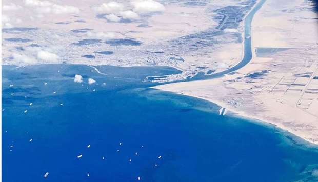 An aerial view taken yesterday from the porthole of a commercial plane shows stranded ships waiting in queue in the Gulf of Suez to cross the Suez Canal at its southern entrance near the Red Sea port city of Suez, as the waterway remains blocked by the Panama-flagged container ship MV Ever Given