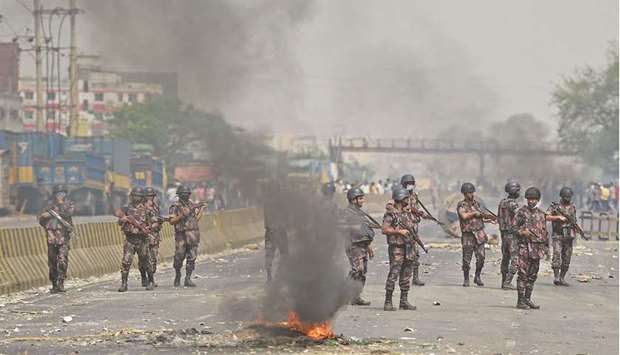 Border Guards Bangladesh (BGB) personnel stand guard as activists block a road during a nationwide strike following deadly clashes with police, in Narayanganj, about 16km southeast of Dhaka, yesterday.