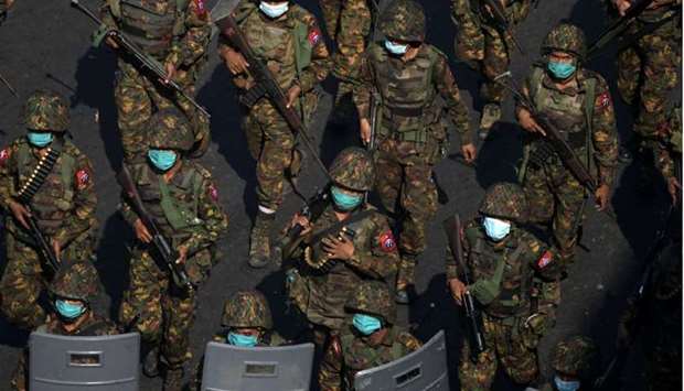 Myanmar soldiers from the 77th light infantry division walk along a street during a protest against 