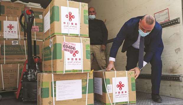 Staff members of the Palestinian Ministry of Health unload a shipment of the Sinopharm Covid-19 vaccines donated by the Chinese government in the city of Ramallah in the West Bank, yesterday.