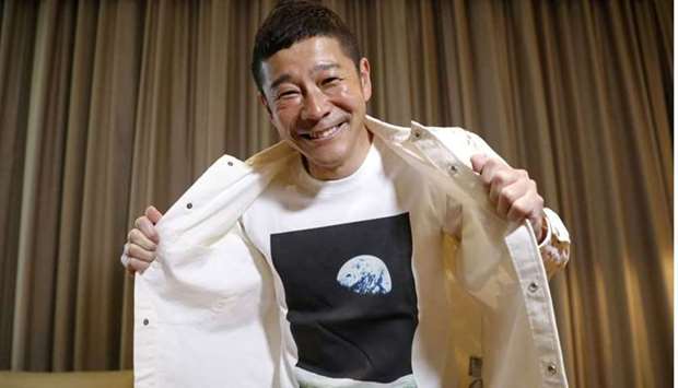 Japanese billionaire Yusaku Maezawa poses with his T-shirt bearing an image of Earth during an interview with Reuters in Tokyo.