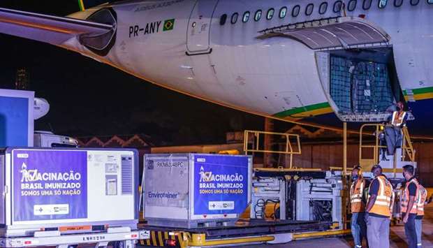 Refrigerated containers carrying AstraZeneca and the University of Oxford Covid-19 vaccines exit from a cargo aircraft at Galeao Air Base in Rio de Janeiro, Brazil. The biggest vaccination campaign in history is underway around the world. More than 574mn doses have been administered across 141 countries and the latest rate was roughly 14.8mn doses a day.