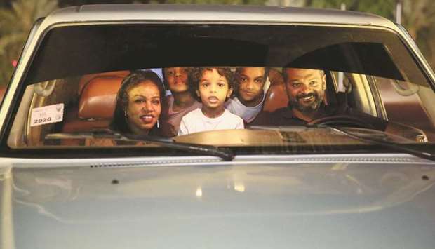 People are seen through their car window as they watch a screening of the Sudanese European Film Festival at an outdoor, drive-through cinema for visitors, adhering to coronavirus disease (Covid-19) restrictions, in Khartoum.