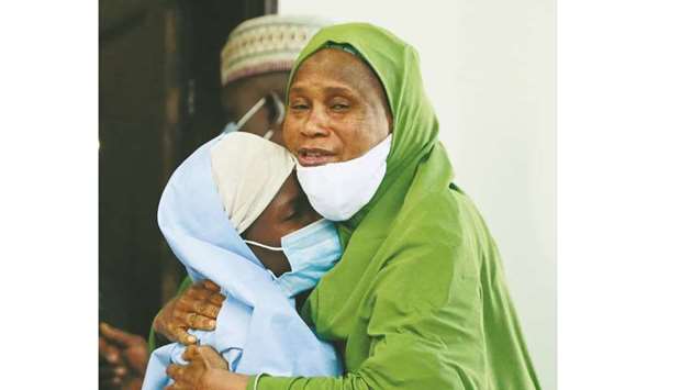 An official embraces a girl who was kidnapped.