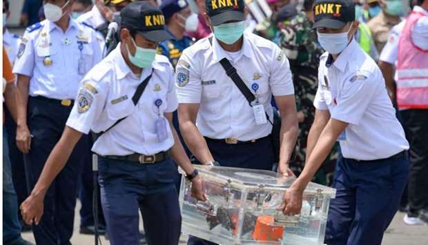 Indonesian officials carry a box contain cockpit voice recorder (CVR or blackbox) at the port in Tanjung Priok in Jakarta after it was recovered during search operations for the Sriwijaya Air Boeing 737-500 passenger jet which disappeared after taking off from Jakarta's international airport on January 9.