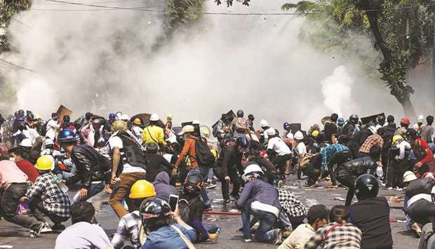 Protesters react after police fired tear gas during a demonstration against the military coup in Mandalay, Myanmar, yesterday.